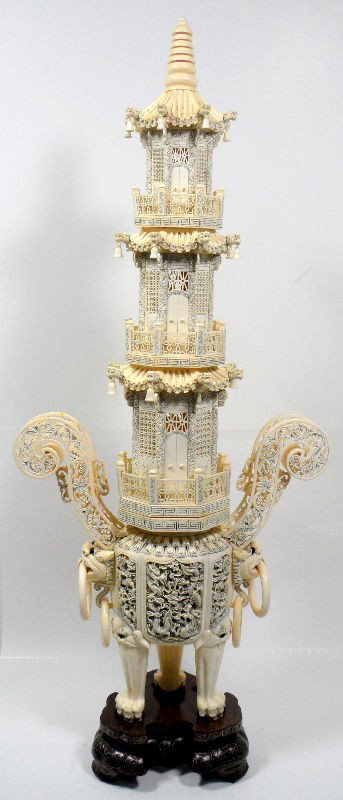 Chinese Ivory Carving of a Temple: Chinese Ivory carved temple. This unique piece incorporates two carved ivory parts that connect to form a whole. The stop piece is a 3-story temple with pirced windows, ivory bells, and intricate carv