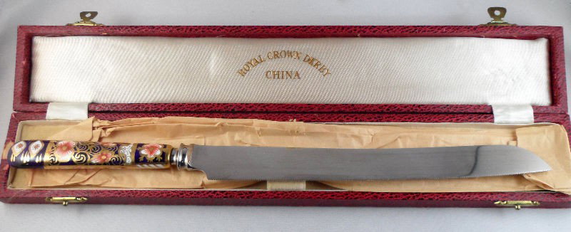 Royal Crown Derby Bread Knife: Royal Crown Derby bread knife in the Traditional Imari pattern. The blade is marked "Made Specially for England The Royal Crown Derby Porcelain Co. Ltd." Comes in its original box. Measures 12"L. For 
