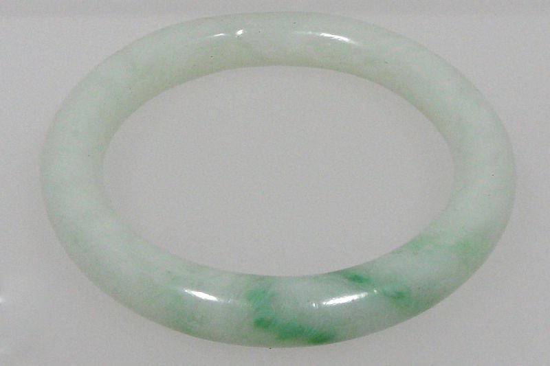 Jade Bangle Bracelet: Jade bangle bracelet. This jade bracelet is natural jade. Of green and white variety in classic round style approx 4 mm thick. For shipping and insurance quotes please call Ryan or Dave at Eagle Shipp