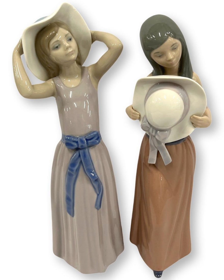 Pair of Lladro Porcelain Figurines: Pair of Lladro Porcelain Figurines includes #5007 Bashful & #5011 Coy Girl Trying on Hal measures H: 9 3/4"