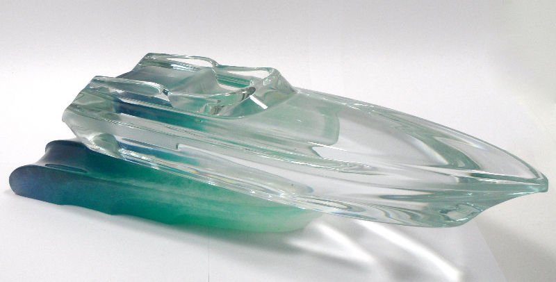 Daum Crystal Pâté de Verre Monaco Powerboat: Daum's Monaco power boat. Speed boat is clear and sits on a ocean blue, green & white pate de verre wave. Boat length 14 1/2", base 17". For shipping and insurance quotes please call Ryan or Dave at E