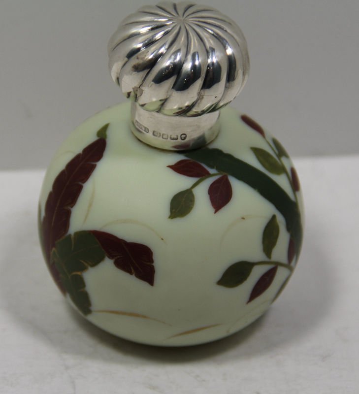 English Silver & Porcelain Perfume Bottle: English silver and porcelain perfume bottle decorated with leaves and branches. Top screws on and has all hallmarks. Measures 4" high x 2 7/8" wide. For Domestic or International Shipping Quotes Pleas