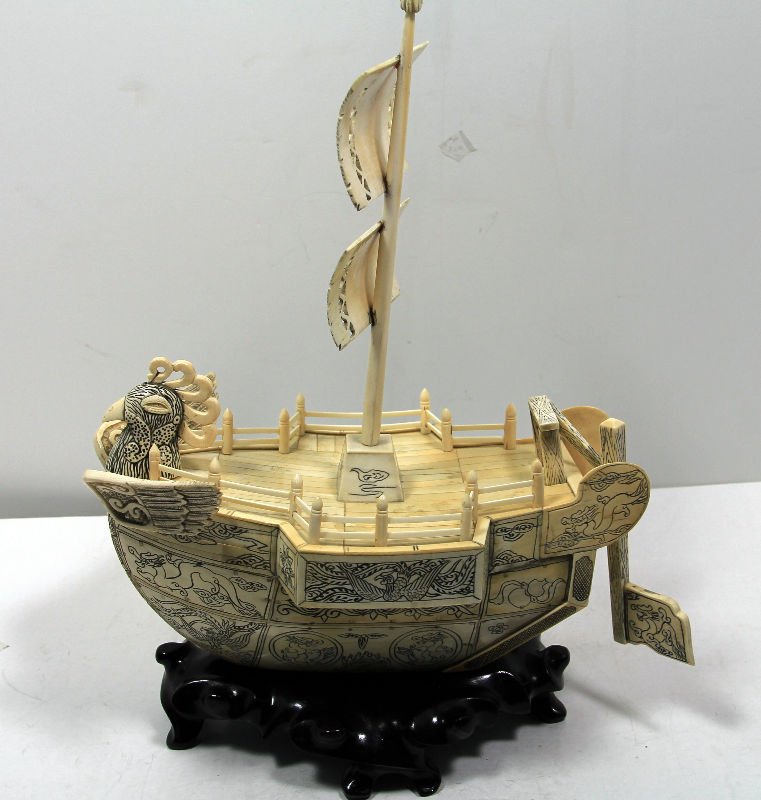 Chinese Carved Ivory Phoenix Boat: Chinese Carved Ivory Phoenix Boat with a phoenix's head protruding from one end. There are flags with writing on them. Fitted wood base included. Measures 11 1/2" high x 10 1/2" wide.For Domestic or I