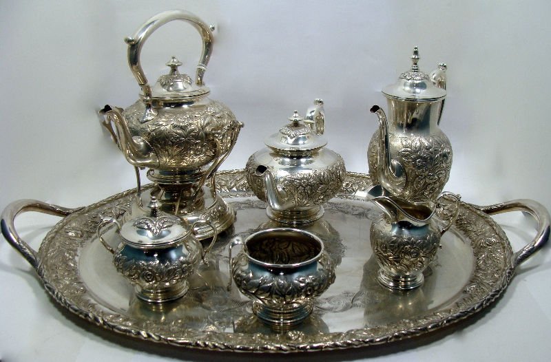 Kirk & Son Repousse Sterling Teaset (9 pc.): Magnificent Kirk & Son sterling silver hand decorated repousse nine piece teaset comprised of the following, tray 19 1/8" x 28", tea kettle stand 6 3/8" x 7 3/8" wide x 6 1/4" diameter, tea kettle 9" 