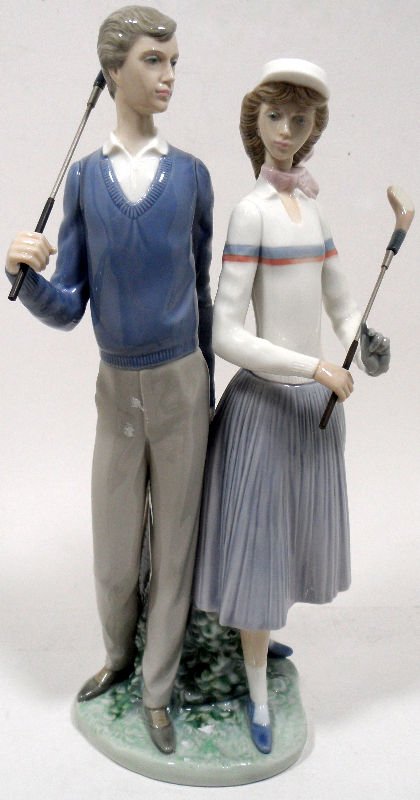 Lladro Porcelain "Golfing Couple" No. 1453: Lladro porcelain "Golfing Couple" No. 1456, issued in 1993 and retired in 2005. Has original box, however the piece is missing one club from the bag. Measures 13 1/4 tall''. For Domestic or Internatio