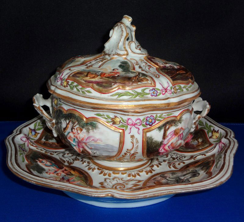 19th Century Capodimonte Covered Bowl w/Underplate: 19th century Capodimonte porcelain figural two handled covered bowl and underplate. The bowl and underplate features various pictures of raised cherub figures. Gilt trimming throughout. The underplate