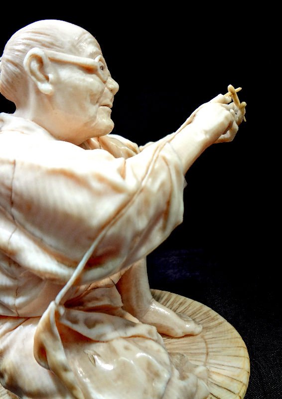 Antique Japanese Carved Ivory Figure: Antique Japanese carved ivory figure of an old man with glasses threading a needle. Measures 5 1/4" high x 4 1/2" wide. For Domestic or International Shipping Quotes Please Feel Call Ryan or Dave at E