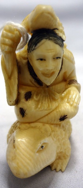 Chinese Ivory Netsuke Man on Frog: Chinese Ivory Netsuke Man on Frog. Depicts a small frog on a man that is on a bigger frog. Measures 1 3/4" high.For Domestic or International Shipping Quotes Please Feel Call Ryan or Dave at Eagle Shi
