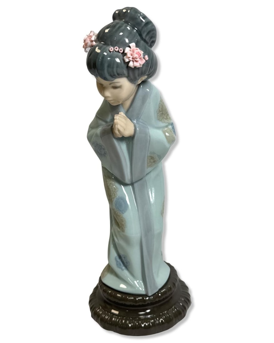 Lladro 4989 Japanese Sayonara Porcelain Figurine: Lladro 4989 Japanese Sayonara Porcelain Figurine measures H: 10 1/2" x W: 4". Missing some flower petals, sold as is
