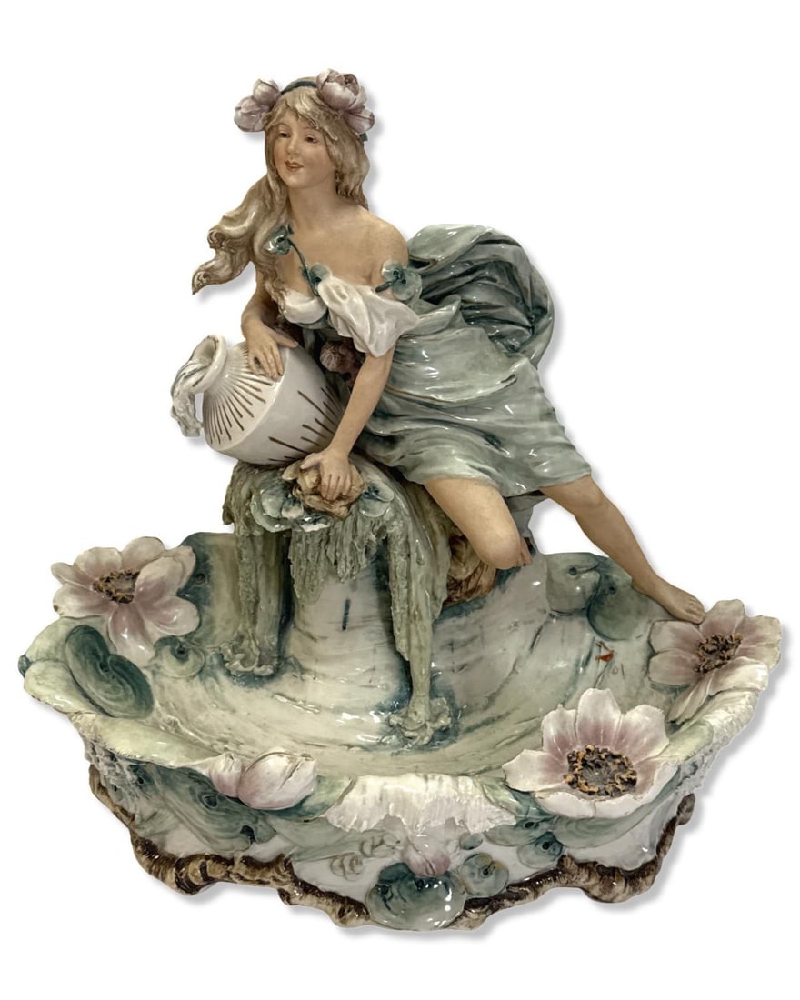 Royal Dux Porcelain Figural Centerpiece of a Seated Woman with a Spilling Jar: Royal Dux Porcelain Figural Centerpiece of a Seated Woman with a Spilling Jar measures H: 13" x W: 14" x L: 9"