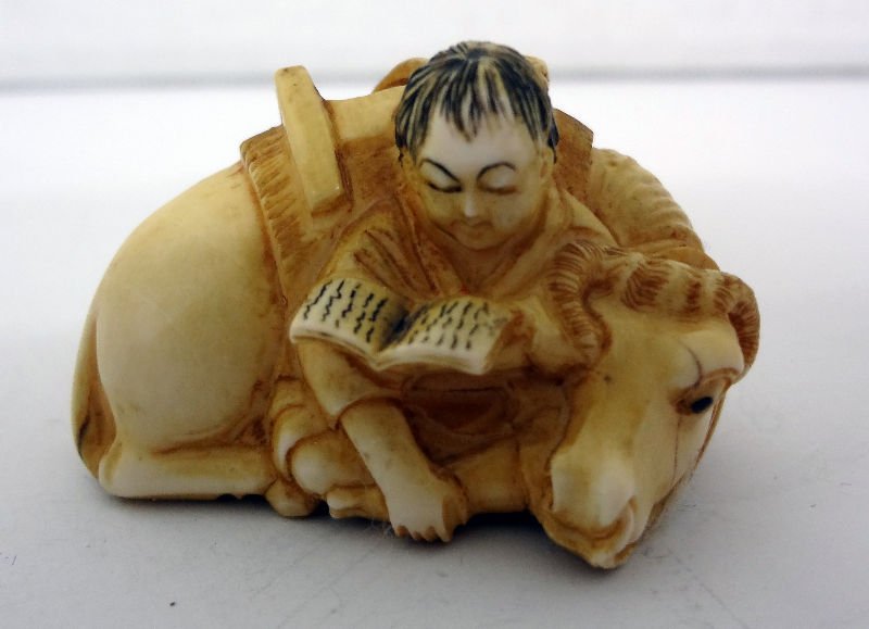 Chinese Ivory Netsuke of Man Reading Next to Cow: Chinese Ivory Netsuke of Man Reading Next to Cow. Measures - 1 3/4" wide. For Domestic or International Shipping Quotes Please Feel Call Ryan or Dave at Eagle Shipping Center 561-932-0700 or email the