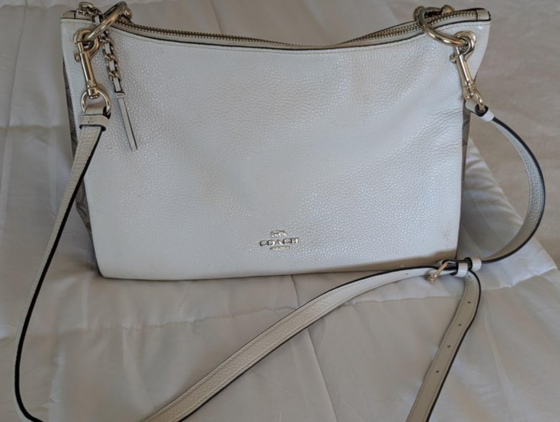 Authentic Coach pebble leather handbag featuring a clean white finish, silver-tone hardware,zip-top: Authentic Coach pebble leather handbag featuring a clean white finish, silver-tone hardware,zip-top closure, adjustable shoulder/crossbody strap, and distinctive animal-print side accents. The bag off