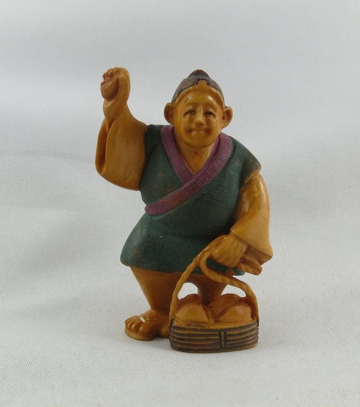 Chinese Hand Carved Ivory Netsuke: Chinese Hand Carved Ivory Netsuke. Depicting chunky man with basket of fruit. Makers mark on the bottom. Measures - 2" high.