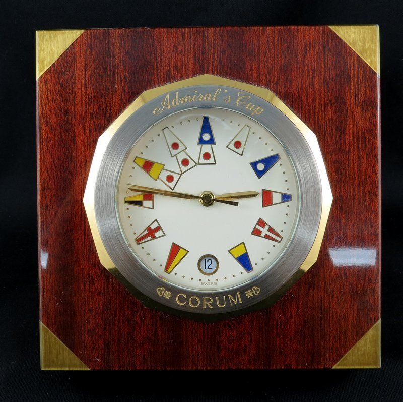 Corum Admiral's Cup Chronometer Desk Clock: Corum Admiral's Cup Chronometer Desk Clock featuring a clock set in a hinged square mahogany base with brass inlays to the corners exhibiting a beautiful lacquered finish, centrally set with a large c