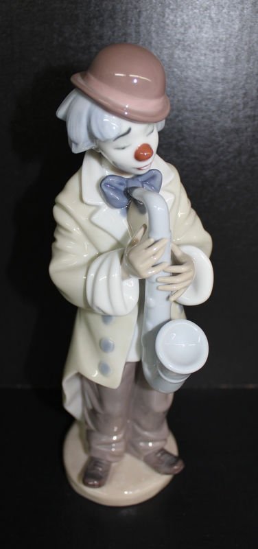 Lladro Clown Sad Sax: Lladro Clown Sad Sax. Lladro glazed porcelain standing clown playing a saxophone. Measures - 8 1/2" high x 2 1/2" wide.