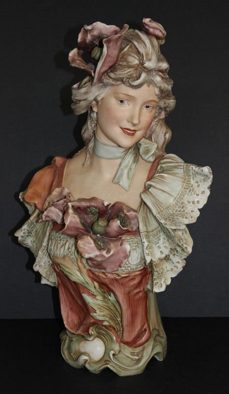 Royal Dux Bohemian Porcelain Bust of a Woman: Royal Dux Bohemian Porcelain Bust of a Woman. Bohemian late 19th century. An ornate and painted porcelain bust of a lady wearing a hat with ribbon and a dress. Royal Dux Bohemian. Measures - 20" high 