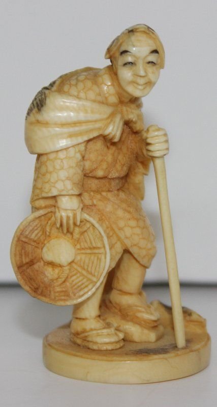 19th C. Japanese Carved Ivory Netsuke: 19th C. Japanese Carved Ivory Netsuke. Finely carved man with staff. Signed on bottom. Measures - 2 3/8" high. Weighs - 21.8 grams.