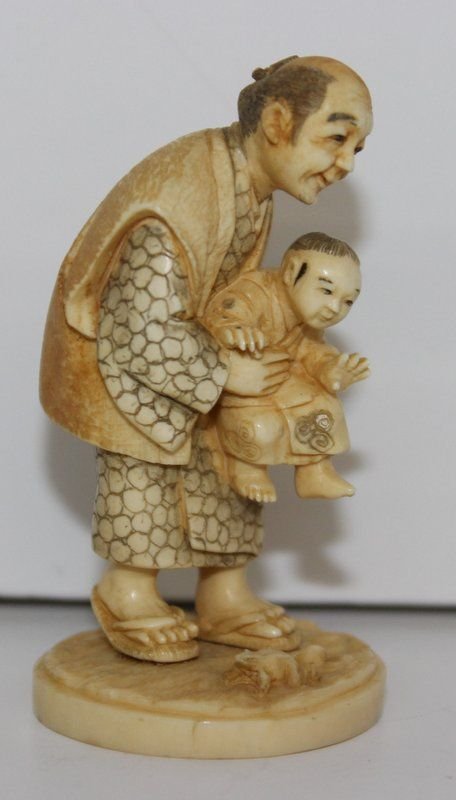 19th C. Japanese Carved Ivory Netsuke: 19th C. Japanese Carved Ivory Netsuke. Finely carved and stained man with child. Signed on bottom. Measures - 2 1/4" high, weighs - 21.3 grams.