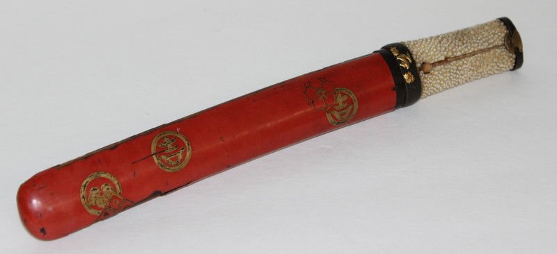 19th C. Japanese Shagreen Handled Tanto: 19th C. Japanese Shagreen Handled Tanto. The shagreen handle with parcel gilt bronze fuchi-kashira, the steel blade in red lacquer scabbard with gilt Japanese symbols. Measures - 12" long.