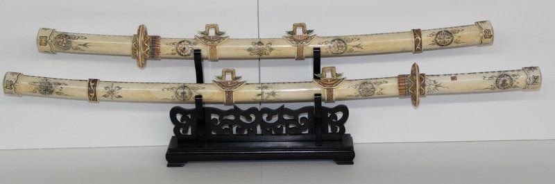Pair of Large Chinese Carved Bone Samurai Swords: Pair of Large Chinese Carved Bone Samurai Swords on rosewood stand. Measures - 38" long x 3" wide, stand - 8 1/2" high x 3 1/4" deep.