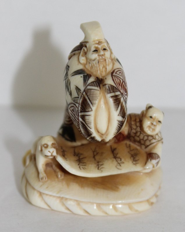 Japanese Polychrome Carved Ivory Netsuke: Japanese Polychrome Carved Ivory Netsuke, depicting man with child and dog. Measures - 1 3/4" high. Weighs - 19.4 g.