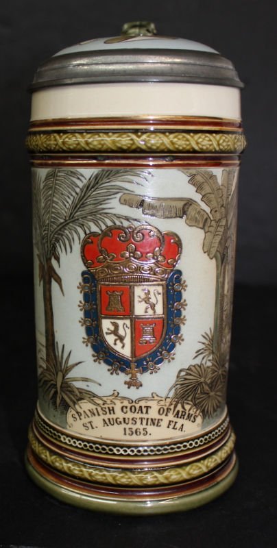 Mettlach St. Augustine Stein #2373: Mettlach St. Augustine Stein #2373. Hand painted etched body featuring the Spanish coat of arms of St. Augustine, FLA 1563 with an alligator handle and pewter top. Measures - 9" high.