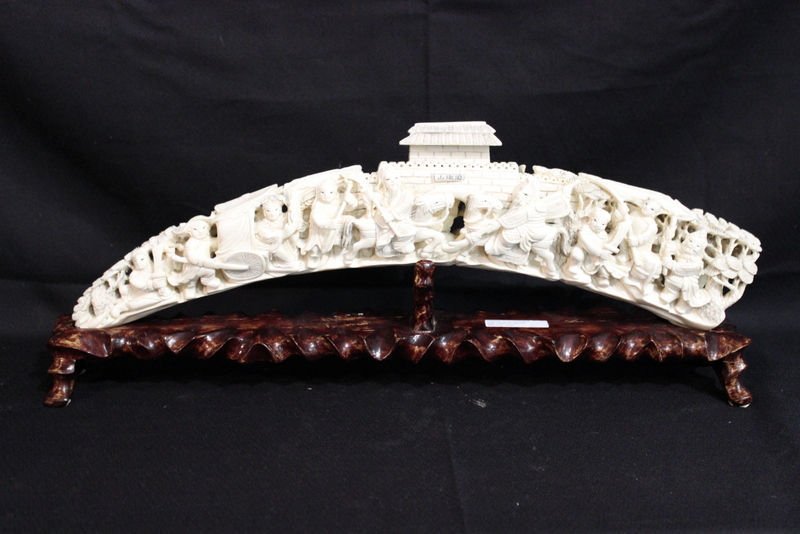 Chinese Intricately Carved Ivory Figural Tusk: Chinese Intricately Carved Ivory Figural Tusk. With fitted wooden stand. Measures - 19" wide x 6" high, 2" base. THIS LOT IS THIRD QUARTER 20TH CENTURY, OR EARLIER ORIGIN. INTERNATIONAL CLIENTS ARE IN
