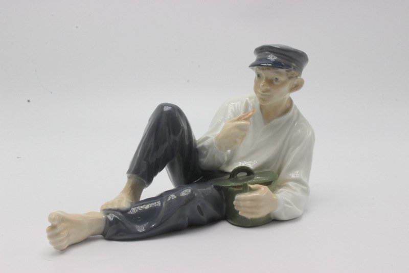 Royal Copenhagen "Reclining Fisherman Eating Biscuit": Royal Copenhagen "Reclining Fisherman Eating Biscuit" Porcelain Figure. Measures - 4 1/4" High x 7 3/4" long.
