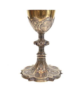 Gilt Sterling Silver Chalice Cup: A 14k, diamond and sapphire inset gilt sterling silver chalice. The silver body with fine religious scenes, an applied gold gem set cross, with cabochons to the stem. Circa 1900.Weight: 26ozt