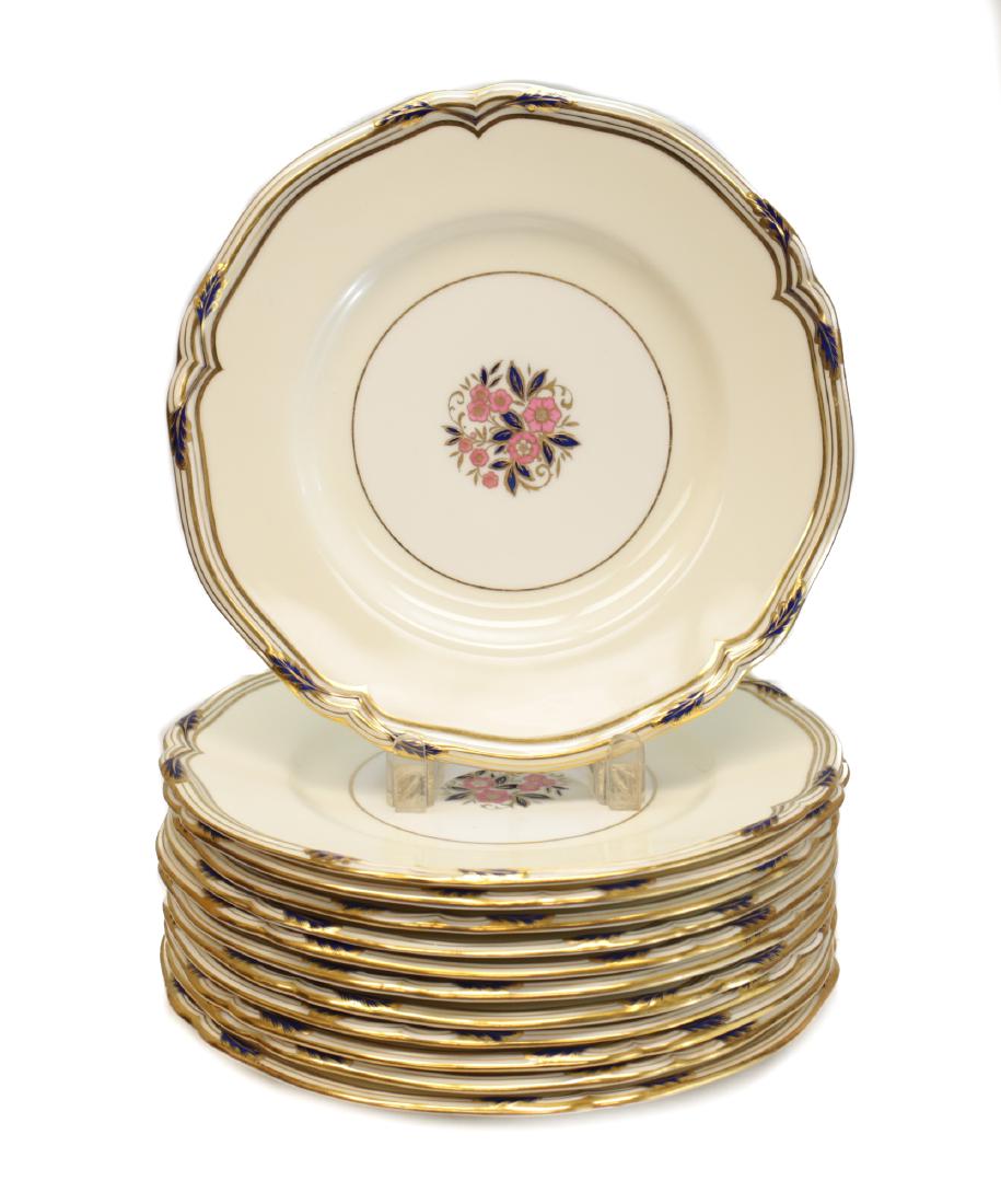 Minton Tiffany & Co Porcelain Dinner Plates: 12 porcelain dinner plates by Minton for Tiffany & Co. Ivory ground with scalloped gilt rims with cobalt highlights and hand painted floral centers. Measures: 10.25 inch diameter Domestic Shipping: $5