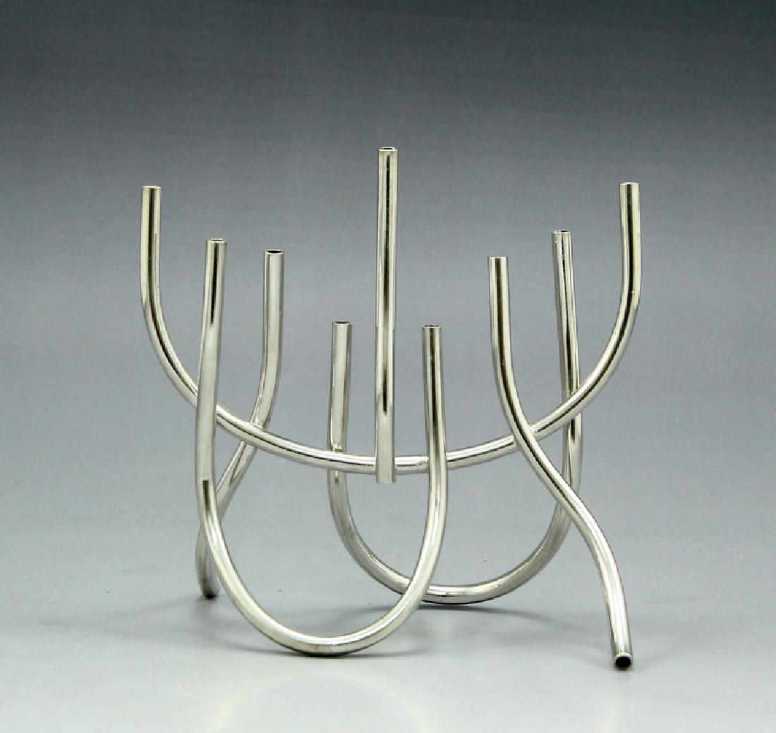 Modern Israeli Hanukkah Menorah: A modern Israeli metal Hanukkah Menorah, designed by Toby Shalom, in the shape of pipes. Height: 16 cm. Width: 16 cm. Signed.