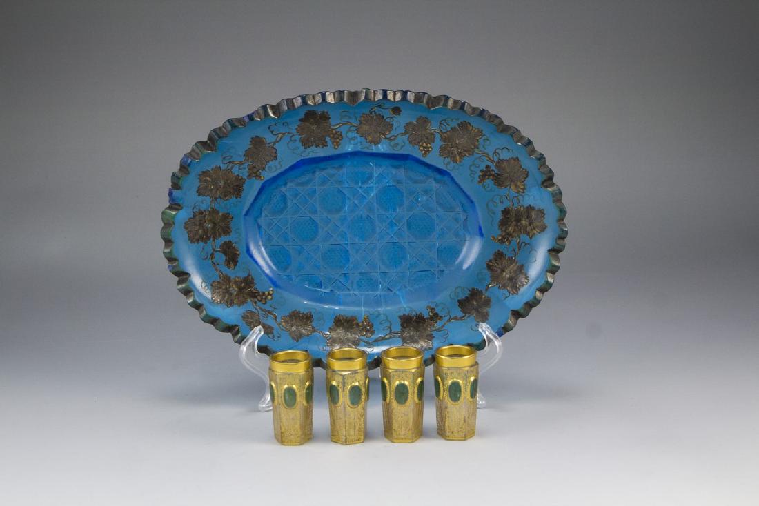 Lot of Bohemian Glass Items: Lot of Bohemian glass items including a bowl (length: 25 cm) and four gilt beakers (height: 5.5 cm). A flaw to the bowl (chip on verso).