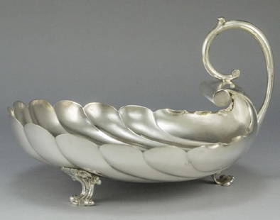 Russian Silver Shell Bowl: A Russian silver shell-shaped fluted bowl. Stands on three legs. With a rounded handle. Length: 22 cm. Weight: 411 grams. Marked.