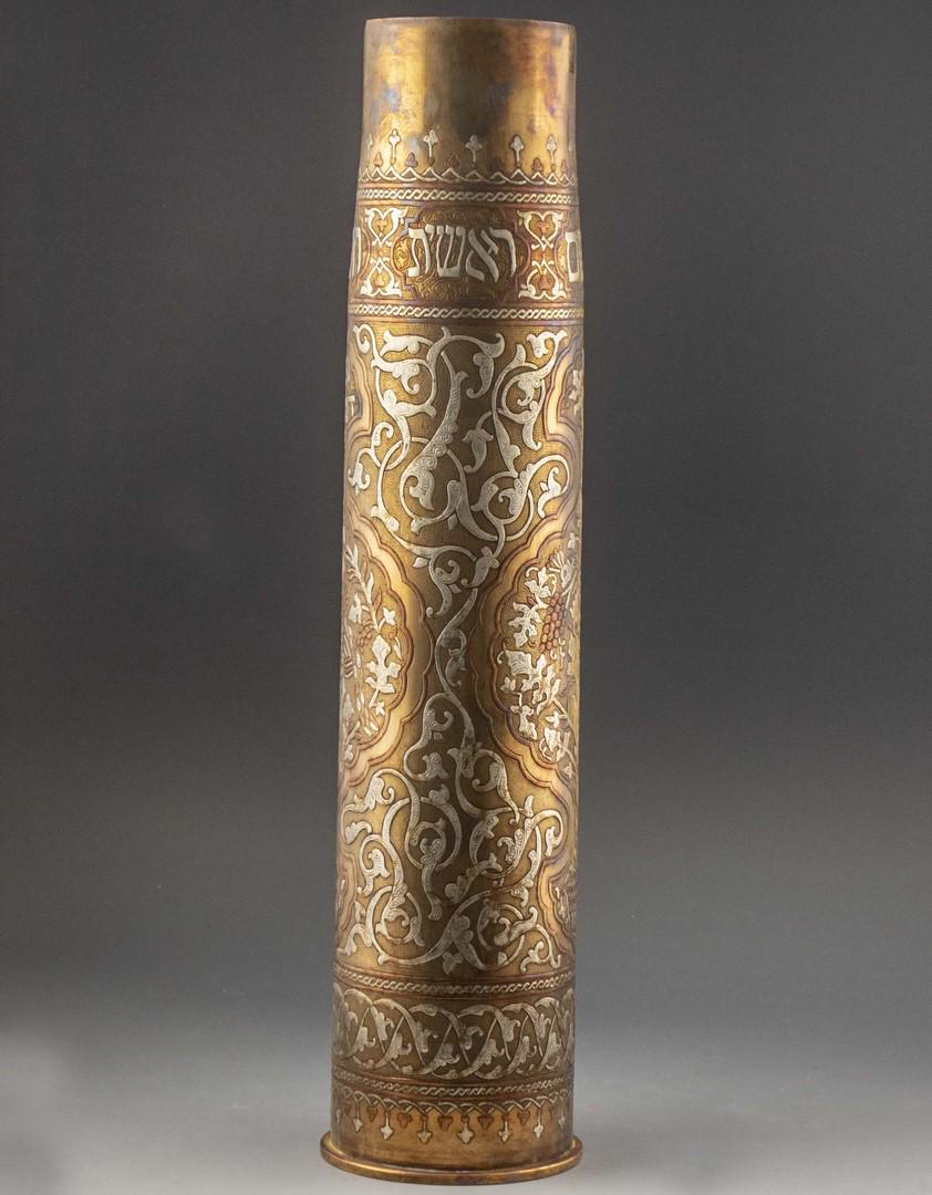 Large Brass Trench Art Shell Case, Jewish Motifs: Large brass Trench Art shell case, inlaid with silver and copper (Damascene), decorated with arabesques, vine motifs, peacocks and a Hebrew inscription. Height: 62 cm.