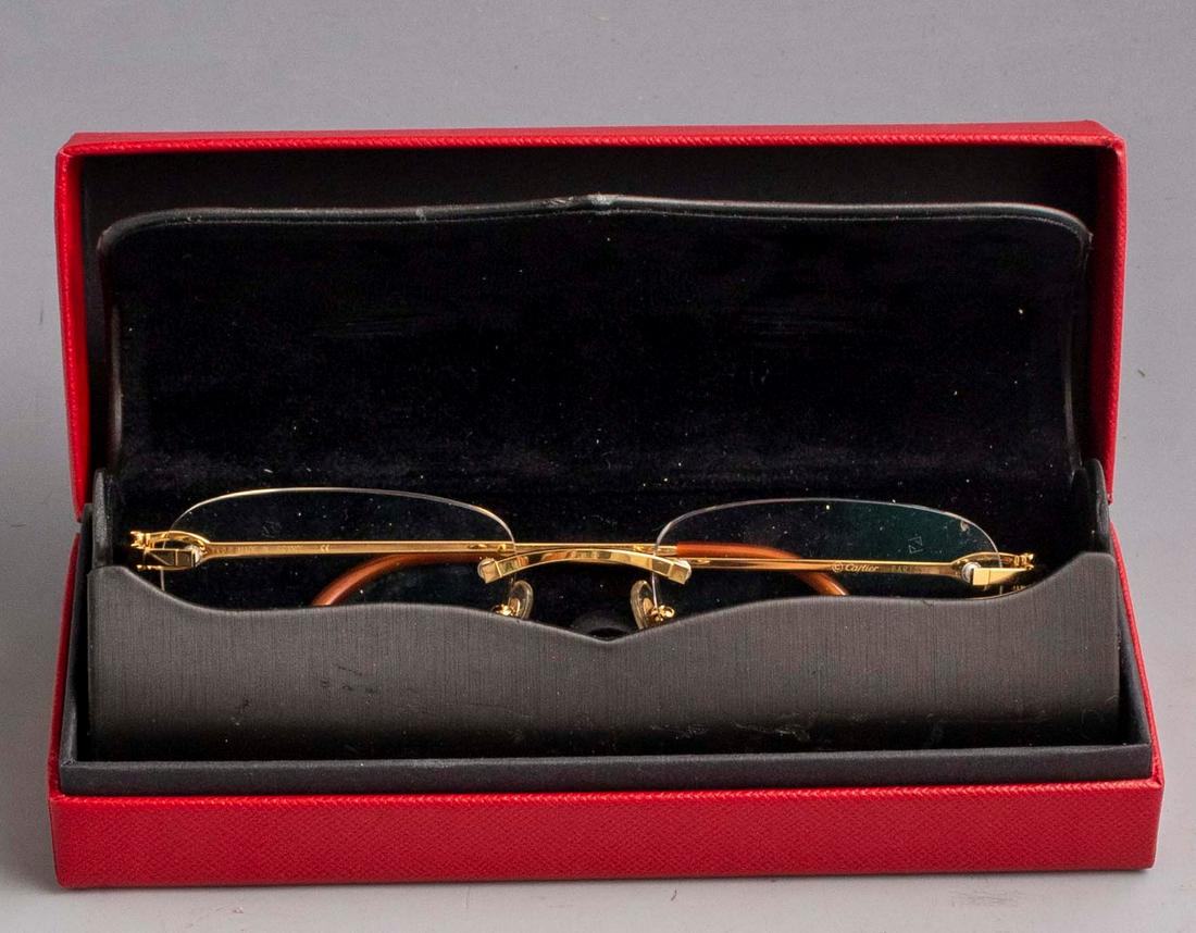 Pair of Cartier Glasses: Pair of Cartier optical glasses, France. Rimless, nose bridge and arms made of gold-colored metal. Size: 20-140. In original case. Mint condition.