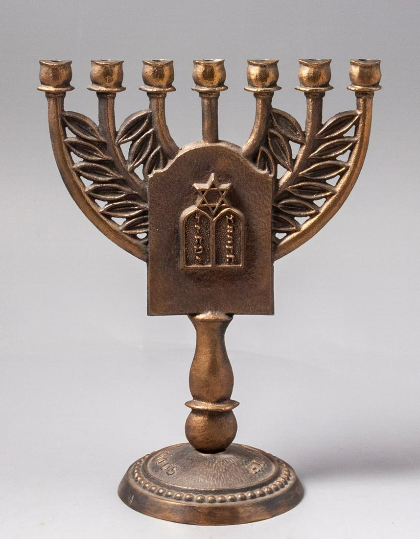 Upright Branched Menorah - "Eich Naflu Giborim" - Commemorating Jewish Rebels in the Hungarian 1848: Upright seven branched Menorah. Hungary, [1940?]. Cast bronze.Decorated with olive branches between the Menorah arms. At the center is a memory plaque inscribed: Elhullottak HÃ¡t a hÅ‘sÃ¶kâ€