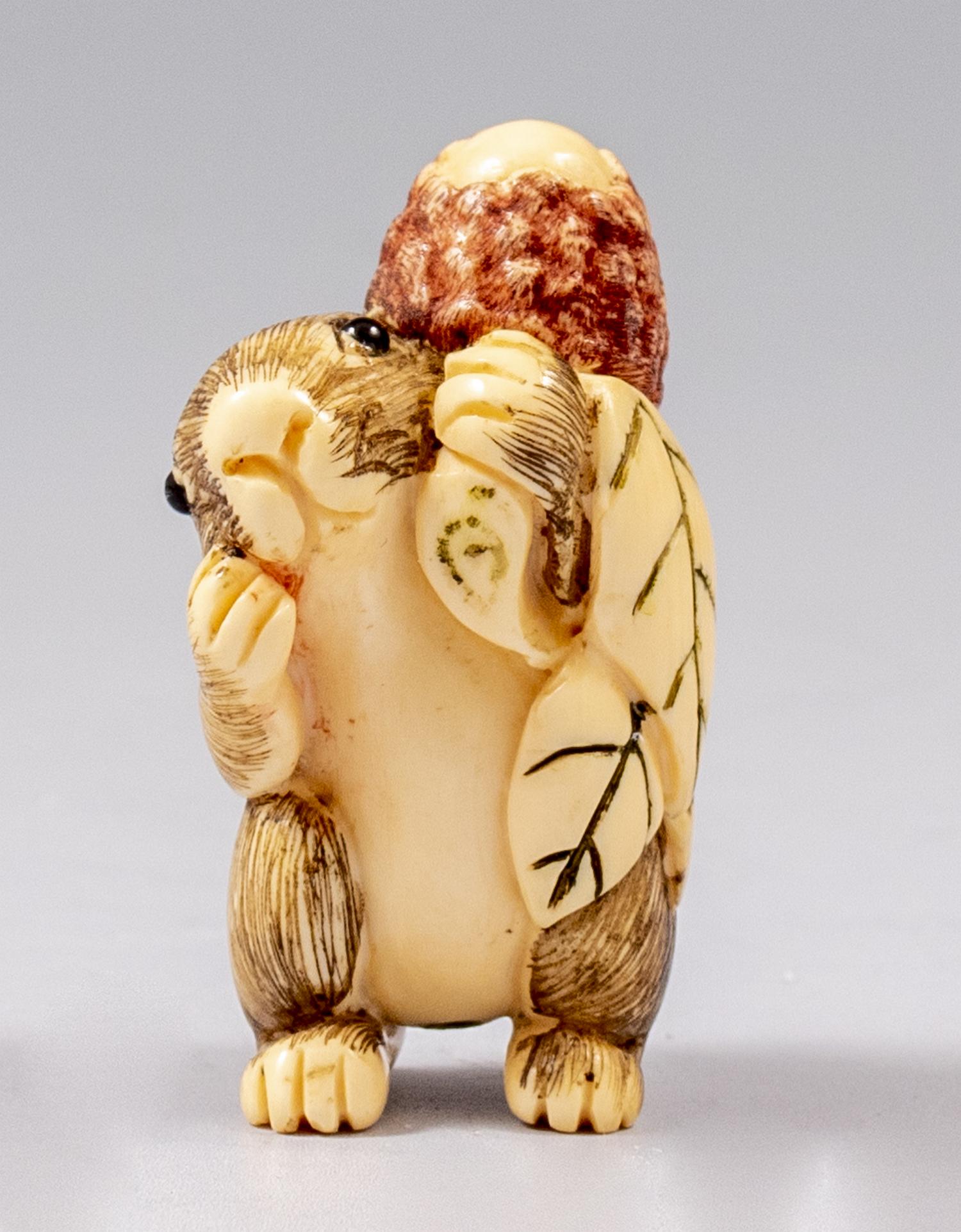 Japanese Carved Netsuke: Japanese Netsuke. Carved in the form of a rabbit with a pinecone. Length: 4.5 cm. Signed.