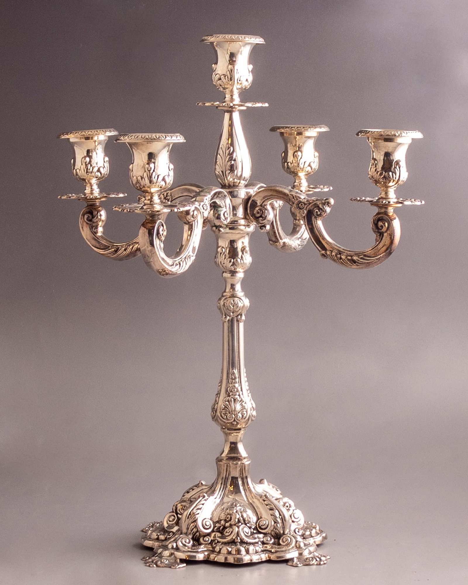 Sterling Silver Candelabra: Sterling silver five branched candelabra. Decorated with reliefs of floral motifs. Height: 37.5 cm. Weight: 789 grams. Hallmarked.
