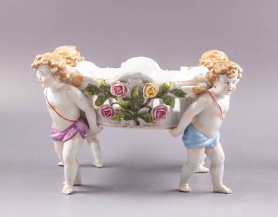 Porcelain Centerpiece/Jardiniere, C.G.Schierholz & Sohn: Porcelain centerpiece/jardiniere by C.G.Schierholz & Sohn, 19th century. Decorated with boys figures and floral motifs. Height: 15 cm. Max. length: 32 cm. Marked. Minor flaws.