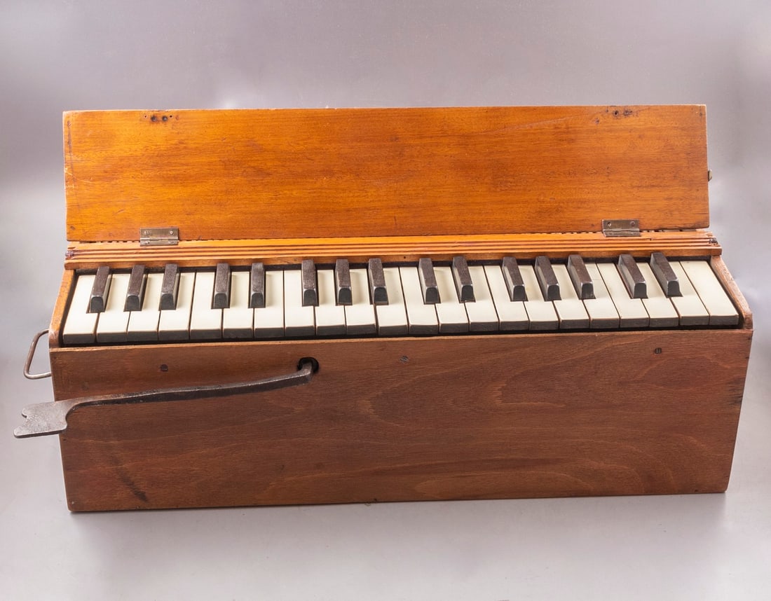 European Wooden Harmonium: Early 20th century European wooden harmonium. In original case. Dimensions of the harmonium: 24X17X53 cm. Case's dimensions: 20X62X28 cm. In working order. Cracks, slight wear to case.