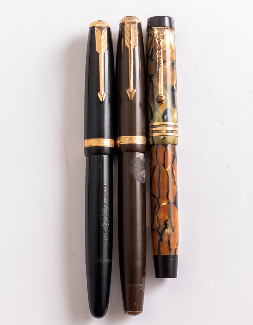 Parker Duofold Fountain Pens: Lot of 3 Parker Duofold fountain pens, various colors and models. Size: 4.5"-5.2" (11.5-13.2 cm). 14K (2) and 18K (1), various sizes. Overall good-very good condition, glue residue to one pen, unknown
