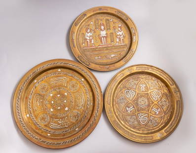 Damascene Brass Trays: Lot of 3 Islamic brass plates, inlaid with silver and copper (Damascene). Decorated with calligraphic motifs, animals and Egyptian figures. Diameter: 29.5-35.5 cm.