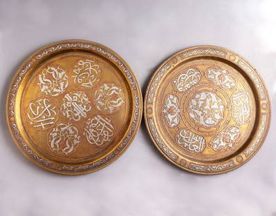 Damascene Brass Trays: Lot of 2 Islamic brass trays, inlaid with silver and copper (Damascene). Decorated with calligraphic and floral motifs. Diameter: 29-30 cm.