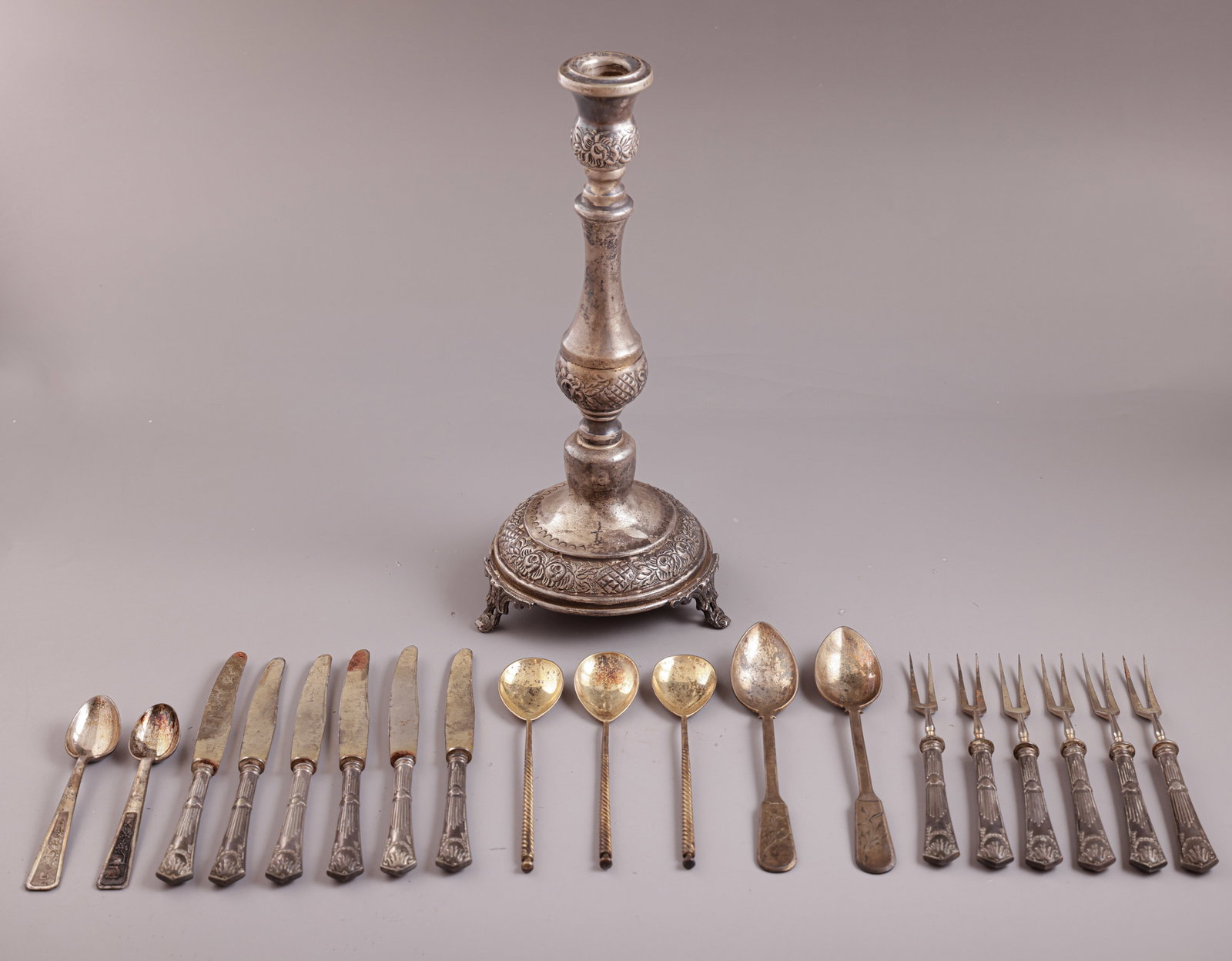 Silver Items, Various Origins: Lot of silver items (800–925), various origins. Including a candle holder, teaspoons, as well as forks and knives with weighted silver handles. Length: 14–25 cm. Total weight (without the