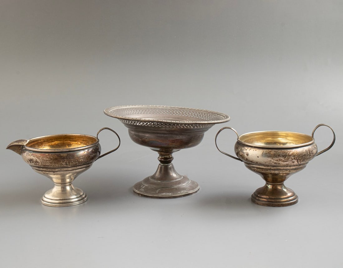 Silver Items: Lot of 3 sterling silver items (weighted), including a tazza, sugar bowl, and creamer. Height: 8.5–9 cm. Total weight including the weighted parts: 394 grams. Hallmarked. Minor flaws (dents).