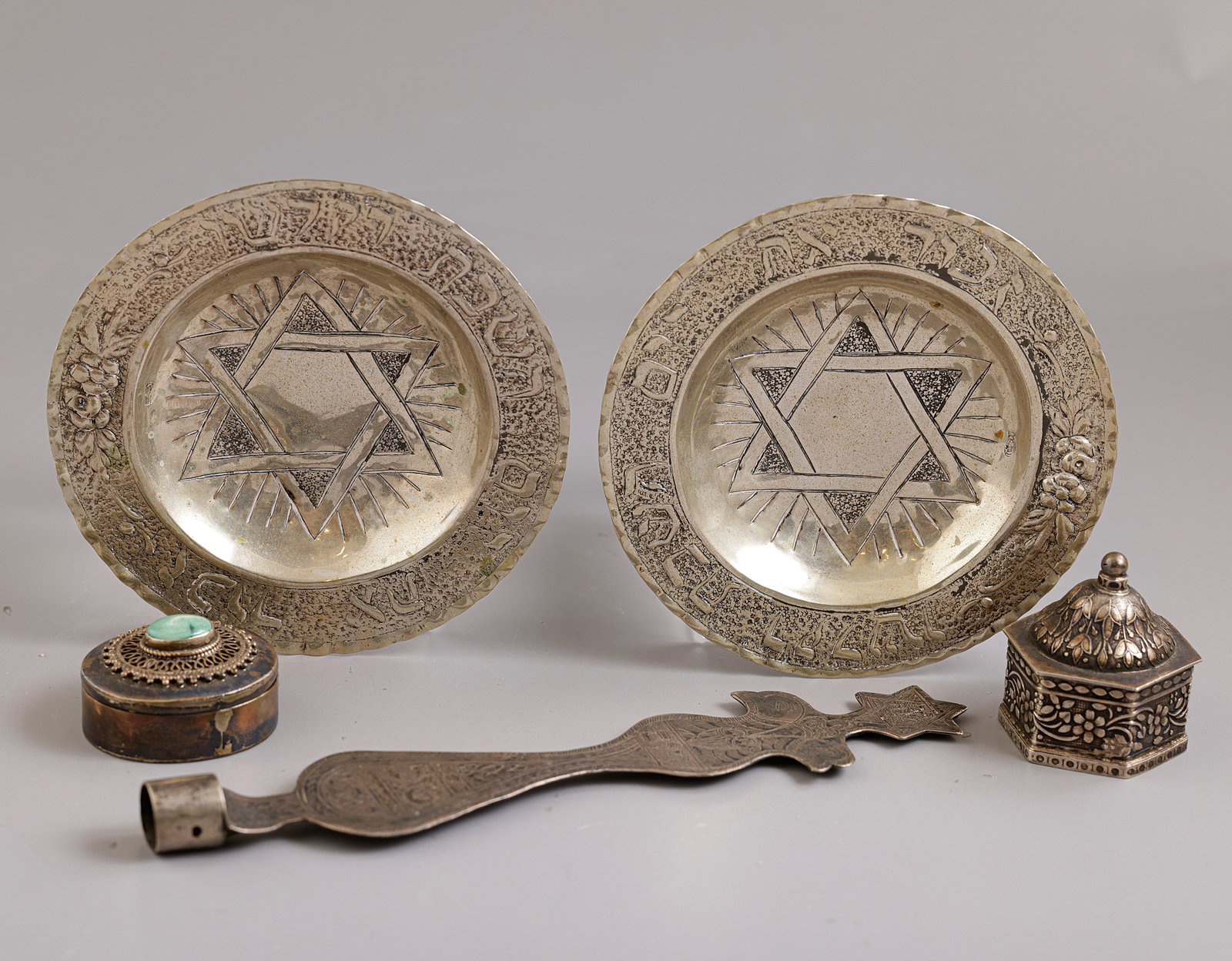 Jewish Silver Items, Various Origins: Lot of 5 silver items (800–925), various origins. Including 2 German Kiddush cup saucers, part of a Havdalah candle holder, and 2 small boxes, one set with turquoise. Length/diameter: 3.5–
