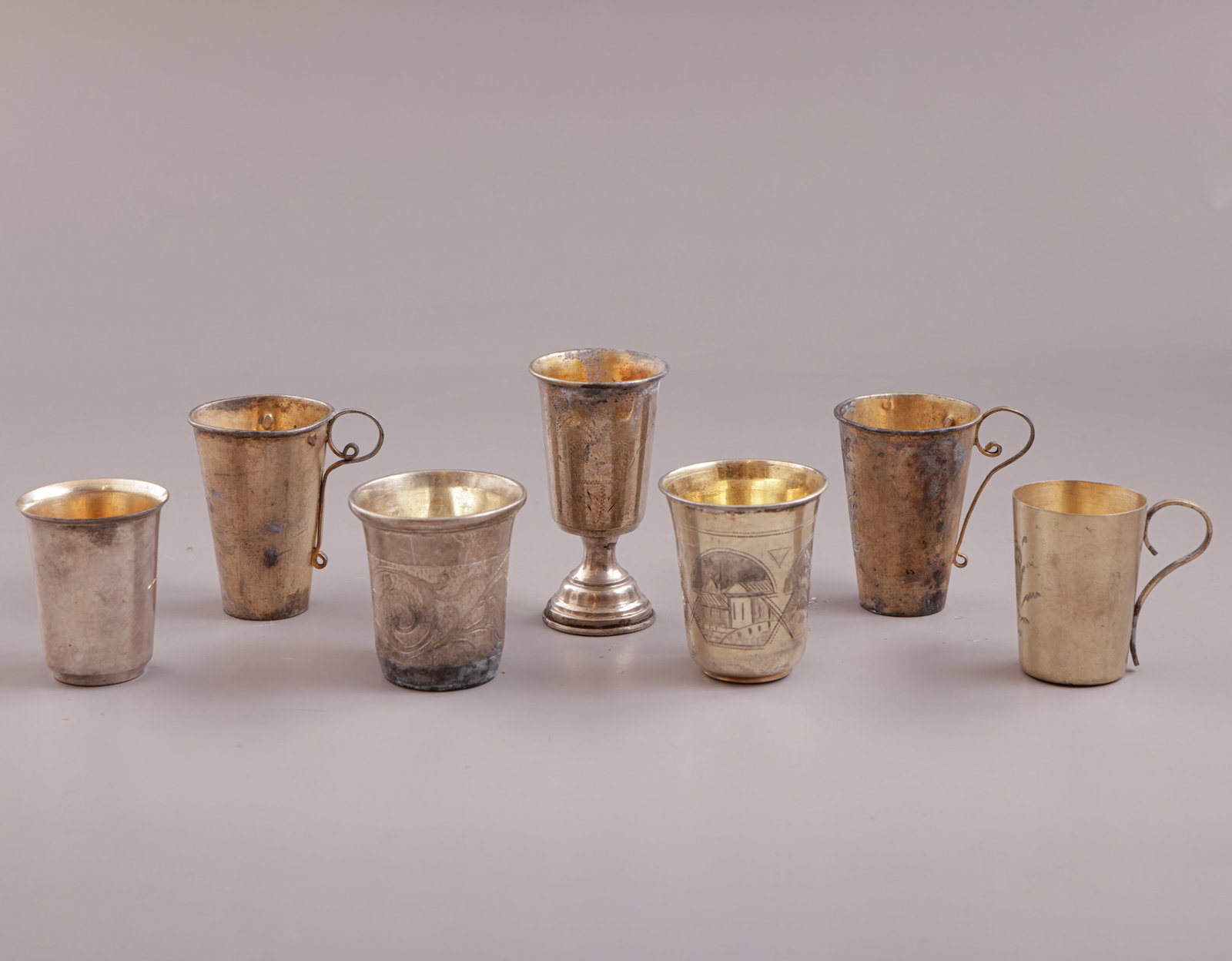 Russian Silver Beakers: Lot of 7 Russian 84/875 silver beakers, decorated with engraved floral motifs. Height: 4.5–7 cm. Total weight: 146 grams. Hallmarked.