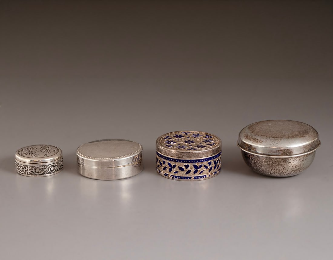 Silver Boxes: Lot of 4 round silver boxes (800–925), one decorated with enamel. Diameter: 3–5.5 cm. Total weight: 62 grams. Hallmarked. Minor flaws to enamel.