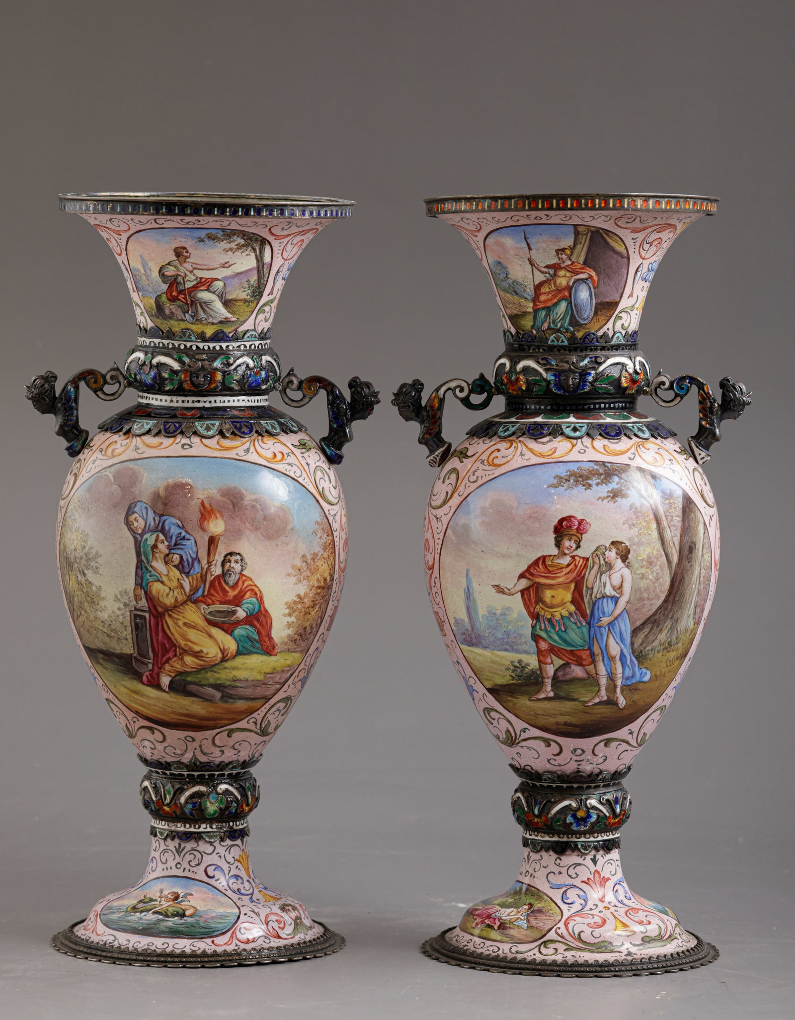 Viennese silver & Enamel Ewers: Pair of Viennese silver ewers, second half of the 19th century. Decorated with enamel work depicting classical scenes and floral motifs. The handles formed as angelic figures. Height: 19.5 cm.
