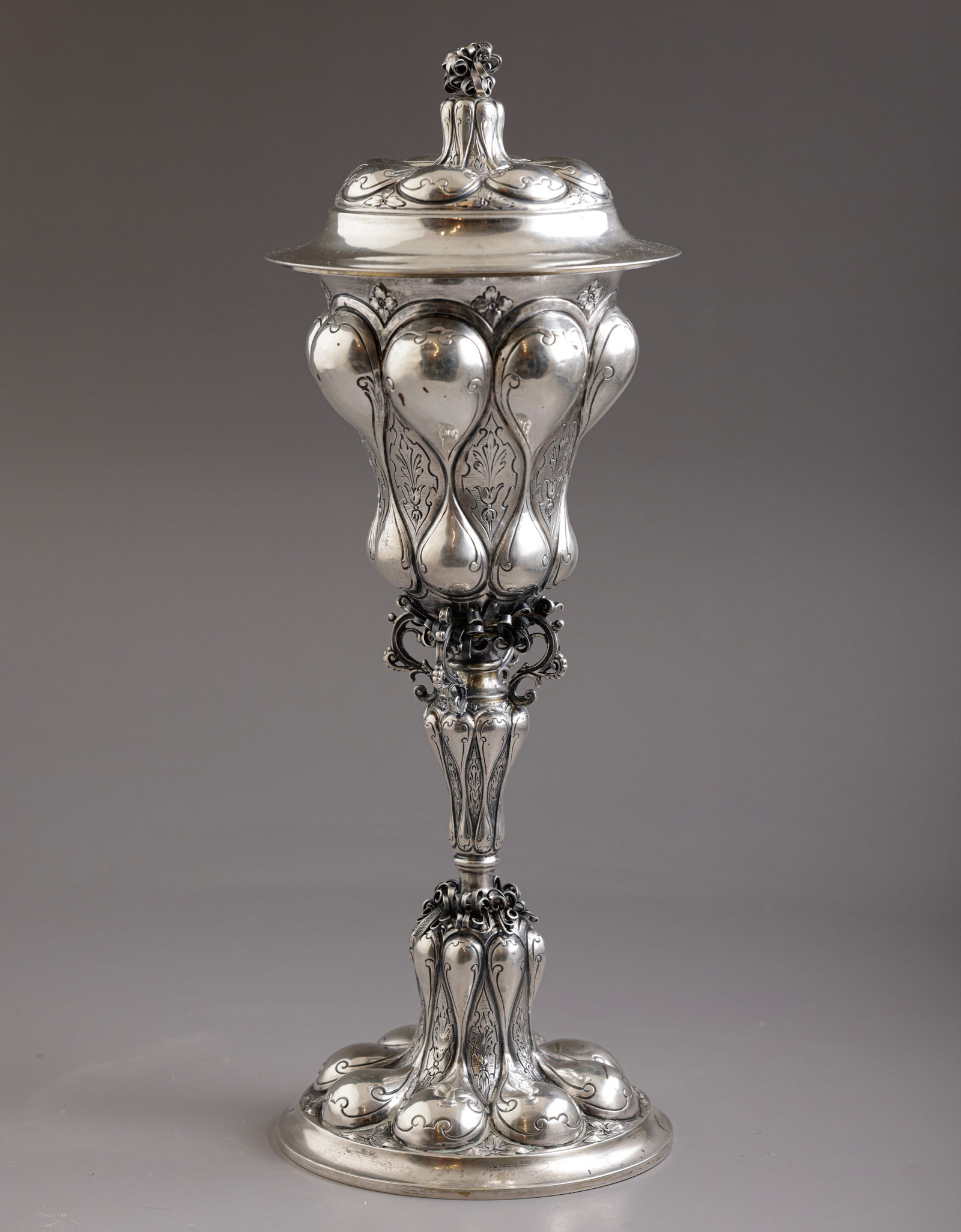 Pineapple Silver Lidded Goblet, Hanau: Large silver lidded goblet by Storck Sinsheimer, Hanau, Germany. Embossed and engraved with floral motifs. Height: 30 cm. Weight: 394 grams. Hallmarked.